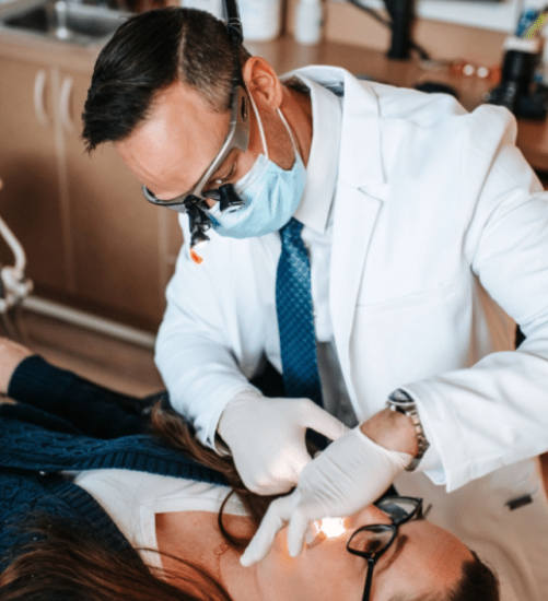 Dr Tolley examining patient's teeth closely.