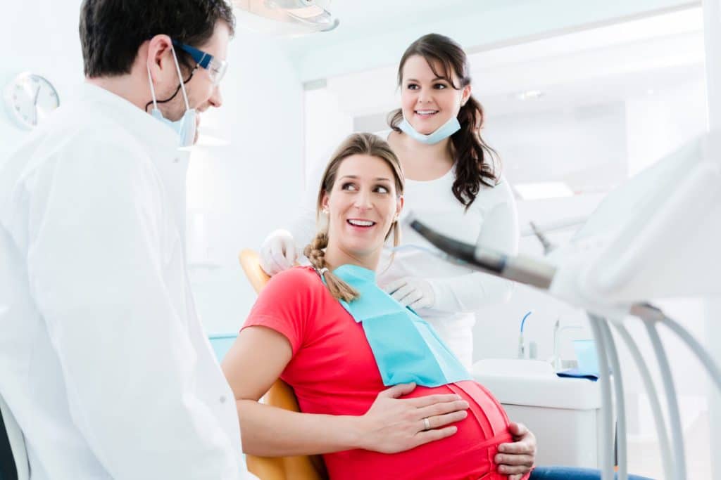 Pregnant woman at dentist before dental x-ray.